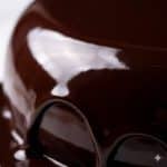 Glaçage miroir au chocolat noir très brillant coulant sur une forme courbe.